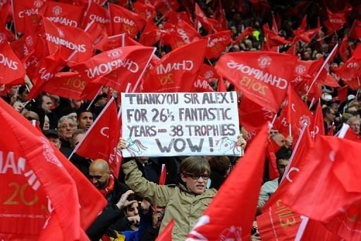 A supporter holds a banner showing support for Alex Ferguson in a sea of red flags on May 12, 2013